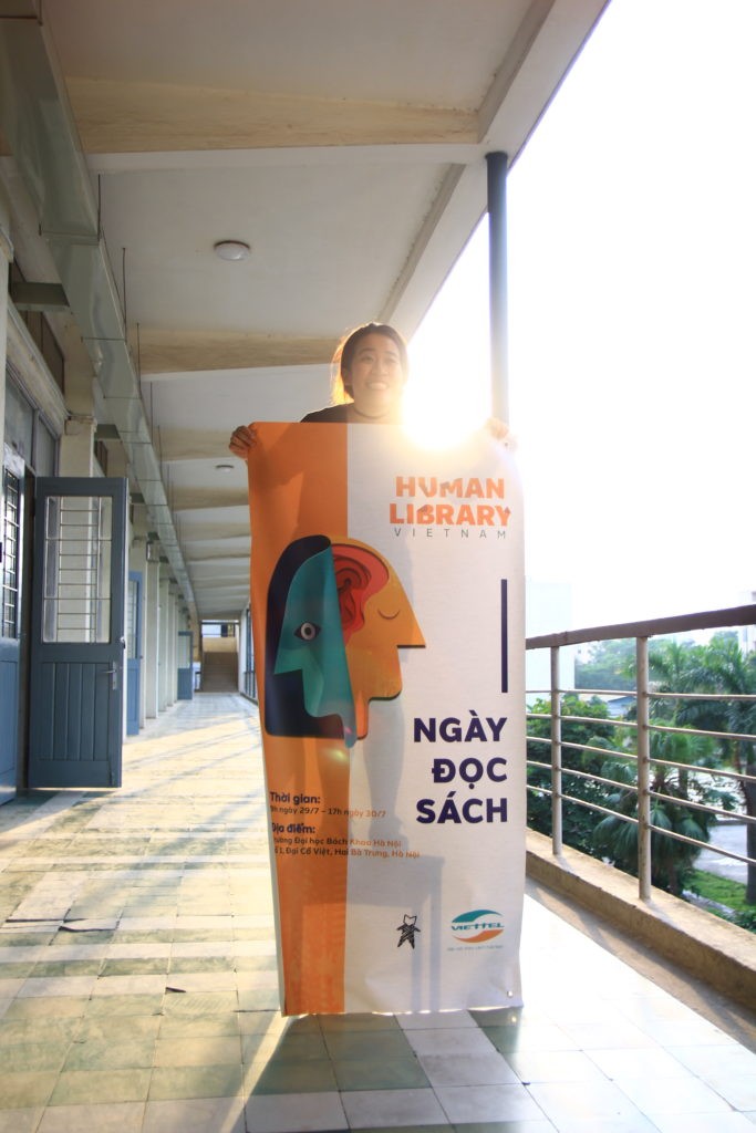 Thu Anh Le holds a poster for a Human Library event. image