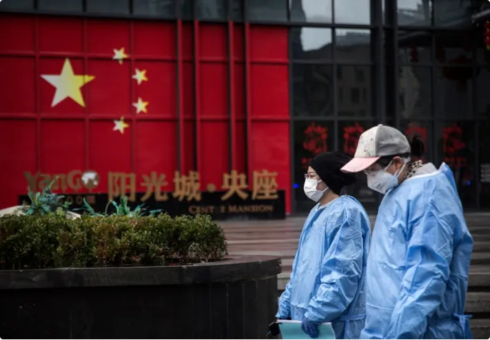 Masked women in front of painted China flag